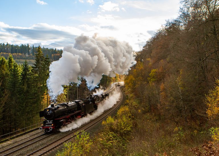 01 150 und 01 202 arbeiten schwer, um den Zug die Schiefe Ebene hochzubefördern. Das Foto zeigt die beiden Dampfloks mit einer enormen Dampffahne am Fotopunkt km80
